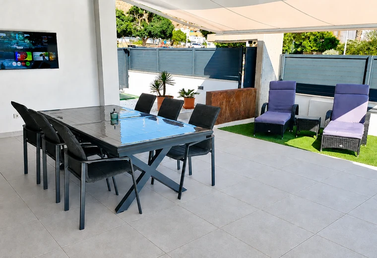 Porche exterior con mesa y zona de descanso